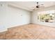 Spacious living room with a ceiling fan, tile flooring, a large window for natural light and neutral walls at 22236 N Arrellaga Dr, Sun City West, AZ 85375