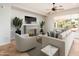 Comfortable living room with fireplace, neutral furniture, ceiling fan, and lots of natural light at 22236 N Arrellaga Dr, Sun City West, AZ 85375