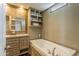 Relaxing bathroom featuring a soaking tub, vanity, and shelving for storage at 255 S 92Nd Pl, Mesa, AZ 85208