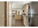 A kitchen with wooden cabinets, dark appliances, and open design, offering a view into the living space at 255 S 92Nd Pl, Mesa, AZ 85208
