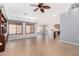 Open-concept living room features a ceiling fan, tile flooring, and large windows with light-filtering shutters at 25536 W Primrose Ln, Buckeye, AZ 85326