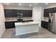 Modern kitchen features dark cabinets, stainless steel appliances, granite countertops, and a central island at 2672 E Bluff Spring Ave, Apache Junction, AZ 85119