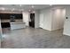 Spacious living room showcasing an open layout to the kitchen with modern gray floors and abundant natural light at 2672 E Bluff Spring Ave, Apache Junction, AZ 85119