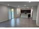 Bright living room featuring an open-concept design leading to a modern kitchen with gray tiled flooring throughout at 2672 E Bluff Spring Ave, Apache Junction, AZ 85119