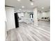 Open-concept living room showcases modern kitchen with white cabinets and gray toned wood flooring at 3338 W Palmaire Ave, Phoenix, AZ 85051