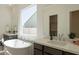 Beautiful bathroom featuring a soaking tub, double sinks, and designer fixtures at 3483 W Sunstone Dr, San Tan Valley, AZ 85144
