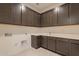 Functional laundry room featuring modern cabinetry, sink, counter space, and stylish flooring at 3483 W Sunstone Dr, San Tan Valley, AZ 85144
