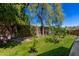 Lush backyard featuring green grass, plants, trees, and a block fence at 3514 W Sands Dr, Glendale, AZ 85310