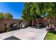Spacious backyard features a grill, patio set, lush trees, and block fence at 3514 W Sands Dr, Glendale, AZ 85310