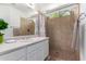 Bright bathroom featuring a walk-in shower with tile surround, large mirror, and vanity with a white cabinet at 3514 W Sands Dr, Glendale, AZ 85310