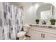 Bathroom featuring a marble countertop, framed round mirror, modern fixtures, and a toilet next to a bathtub at 3514 W Sands Dr, Glendale, AZ 85310