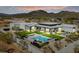 Aerial view of a modern home showcasing a pool, outdoor living spaces, lush landscaping, and mountain views at 36004 N Prickley Pear Rd, Cave Creek, AZ 85331