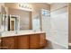 Bright bathroom featuring a double sink vanity and a shower over tub at 44390 W Buckhorn Trl, Maricopa, AZ 85138