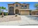 Exterior of a stucco home showcasing a two-car garage and desert landscaping at 44390 W Buckhorn Trl, Maricopa, AZ 85138