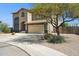 Two-story stucco home featuring a two-car garage, landscaped front yard, and desert-friendly landscaping at 44390 W Buckhorn Trl, Maricopa, AZ 85138