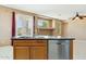 Kitchen island with sink, dishwasher, and wood cabinetry at 44390 W Buckhorn Trl, Maricopa, AZ 85138