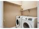 Laundry room featuring side by side appliances and shelving at 44390 W Buckhorn Trl, Maricopa, AZ 85138