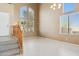 Bright living room with tile floors, staircase, and large windows at 44390 W Buckhorn Trl, Maricopa, AZ 85138