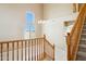 Staircase with wood railing and neutral-toned walls at 44390 W Buckhorn Trl, Maricopa, AZ 85138