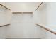 Walk-in closet with white walls, shelves, and wooden railing at 44390 W Buckhorn Trl, Maricopa, AZ 85138