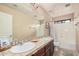 Bright bathroom with double sinks, tile countertops, and a shower-tub combo at 4725 N 152Nd Dr, Goodyear, AZ 85395