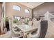 Airy dining room boasts high ceilings, arched windows, and an elegant table with upholstered seating at 4725 N 152Nd Dr, Goodyear, AZ 85395