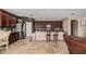 Inviting kitchen with dark wood cabinetry, stainless steel appliances, and an island with barstool seating at 4725 N 152Nd Dr, Goodyear, AZ 85395