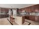 Well-equipped kitchen boasts an island with barstool seating, dark wood cabinets, and modern appliances at 4725 N 152Nd Dr, Goodyear, AZ 85395