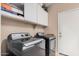 This is a well-equipped laundry room featuring modern washer and dryer, with ample storage cabinets overhead at 4725 N 152Nd Dr, Goodyear, AZ 85395