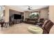 Comfortable living room featuring tile flooring, a ceiling fan, and leather sofas with recliner seating at 4725 N 152Nd Dr, Goodyear, AZ 85395
