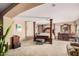 Spacious main bedroom featuring a four-poster bed, sitting area, and lots of natural light at 4725 N 152Nd Dr, Goodyear, AZ 85395