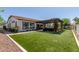Landscaped backyard with artificial turf, a covered patio, and an outdoor kitchen at 5114 S Leisure Ct, Gilbert, AZ 85298