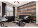 Stylish living room with a modern accent wall, leather sofa, and a window with shutter blinds at 5114 S Leisure Ct, Gilbert, AZ 85298