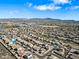 Wide aerial showcasing the suburban neighborhood and the surrounding desert landscape, mountain views and a community lake at 5318 W Grenadine Rd, Laveen, AZ 85339