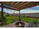 Inviting backyard with a pergola, string lights, and a cozy fire pit perfect for relaxing evenings outdoors at 5318 W Grenadine Rd, Laveen, AZ 85339