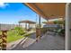 Covered patio overlooking a well-maintained backyard with a pergola creating a relaxing outdoor living space at 5318 W Grenadine Rd, Laveen, AZ 85339