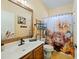 Charming bathroom with a rustic wood-framed mirror and a cow-themed shower curtain adding a touch of whimsy at 5318 W Grenadine Rd, Laveen, AZ 85339