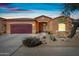Charming single-story home featuring a two-car garage, desert landscaping, and a welcoming entrance at 5318 W Grenadine Rd, Laveen, AZ 85339