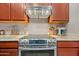 New stainless steel range with hood, wood cabinets, and stylish countertops create an updated kitchen at 5318 W Grenadine Rd, Laveen, AZ 85339