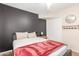 Cozy bedroom features a comfy bed with a red blanket and a dark accent wall at 533 W Guadalupe Rd # 1001, Mesa, AZ 85210