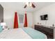 The bedroom has a mounted TV and a window with decorative, orange curtains at 533 W Guadalupe Rd # 1001, Mesa, AZ 85210