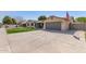 Spacious home featuring an expansive driveway, stone accents, and a well-manicured lawn at 5333 E Catalina Ave, Mesa, AZ 85206