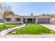 Charming home featuring a lush front lawn, stone accents, shutters, and a welcoming two-car garage at 5333 E Catalina Ave, Mesa, AZ 85206