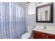 Neat bathroom featuring blue and white patterned shower curtain and cherry-stained vanity at 6279 S Martingale Ct, Gilbert, AZ 85298