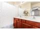 Bright bathroom showcasing a double sink vanity with cherry-stained cabinets and a shower-tub combo at 6279 S Martingale Ct, Gilbert, AZ 85298