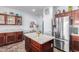 Well-appointed kitchen with stainless steel refrigerator, granite counters, and dark wood cabinetry at 6279 S Martingale Ct, Gilbert, AZ 85298