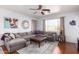 Spacious living room featuring a comfortable gray sectional, hardwood floors, and large windows at 6279 S Martingale Ct, Gilbert, AZ 85298