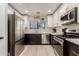 Modern kitchen boasts stainless steel appliances, white cabinets, black lowers, and sleek countertops at 640 E Browning Way, Chandler, AZ 85286
