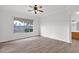 Empty bedroom with wood floors, white walls, a large window, and a ceiling fan at 6793 W Angela Dr, Glendale, AZ 85308