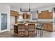 Open kitchen with a granite island, wooden cabinets, stainless steel microwave, and wooden floors at 6793 W Angela Dr, Glendale, AZ 85308